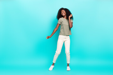 Full length portrait of pretty cheerful girl chilling have fun dancing isolated on vivid teal color background