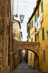 Vicolo della Tartuca, a medieval blind alley with a flying bridge, in the Contrada della Tartuca, Siena, Tuscany, Italy