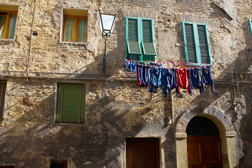 Washing hanging out to dry: Vicolo della Tartuca, a medieval blind alley, in the Contrada della Tartuca, Siena, Tuscany, Italy