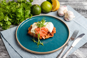 Waffles with red fish, waffles with fish and vegetables on wooden white