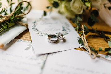Stylish rings, flowers on wooden table background. Letters from the bride and groom. Vows....