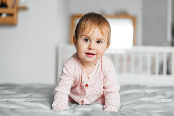 Cute baby girl crawling on the bed
