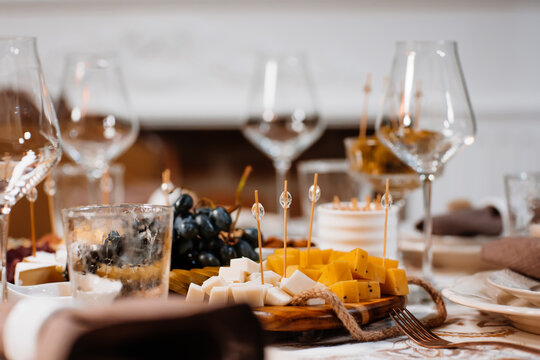 Happy Thanksgiving background, wooden table with glasses and grapes and sliced cheese