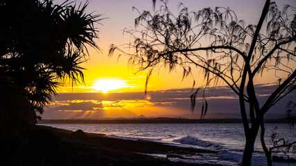 colourful sunset in noosa national park in queensland, australia; famous surf beaches in australia, silhouettes of surfers at sunset