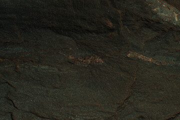 Photo of the texture of natural stone. The heterogeneous background of dark stone