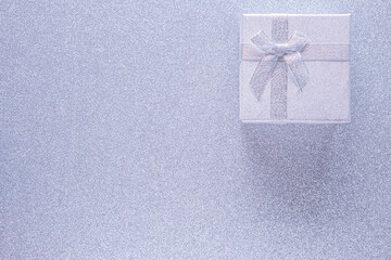 Silver gift box on glitter silver background with copy space. Top view. Xmas, Valentines day or...