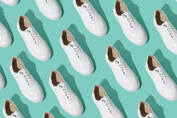 White sneakers pattern on a mint blue background. The shoes are comfortable and casual. Background for a shoe store. A pair of new sneaker shoes.