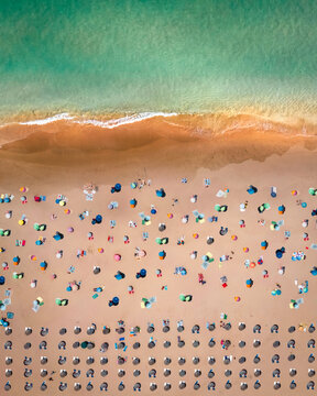 Aerial view of Praia de Odeceixe with people on the beach in summertime, Odeceixe, Faro, Portugal.
