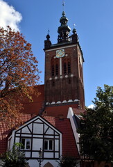 Fototapeta na wymiar Turm der Marienkirche in Danzig hinter einem Fachwerkhaus