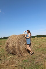 Naklejka na ściany i meble girl resting in a field on a haystack