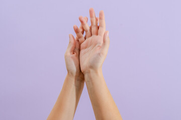 Woman's hands on lilac background. Skin care for hands, manicure and beauty treatment.
