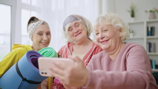 Happy women in their 60s taking selfie after workout, senior's healthy lifestyle