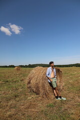 Naklejka na ściany i meble guy resting in a field on a haystack