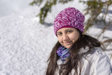 Adolescente con gorro de lana y bufanda en montaña nevada
