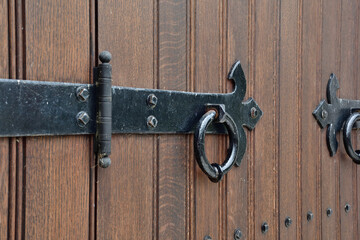 Antique black door knocker on a brown wood door
