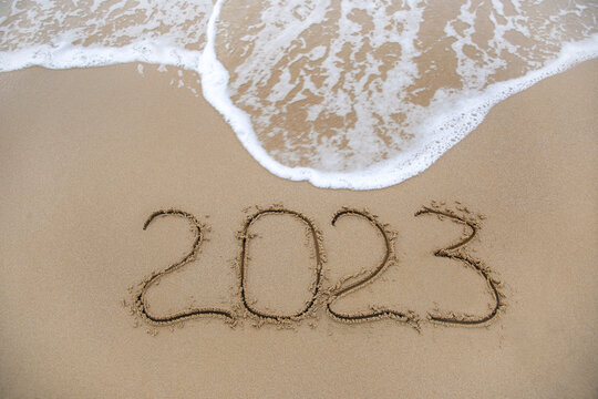 2023 year written on sandy beach sea. Top view. Flat lay.