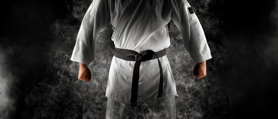 Karate master in white kimono with black belt