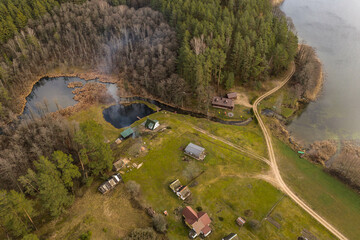 Drone view of cabins in the woods near a lake