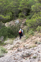 Mujer caminando por una ruta a través de la montaña
