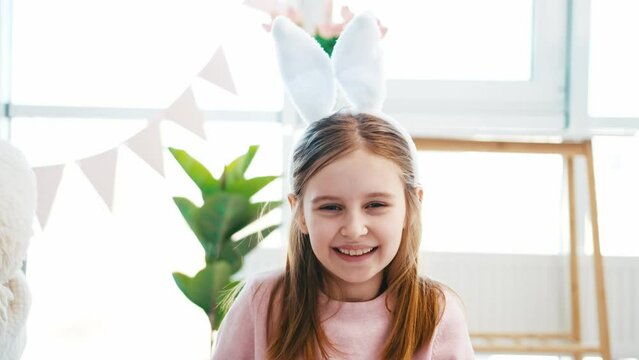 Beautiful little girl in Easter day wearing bunny ears looking at the camera and smiling