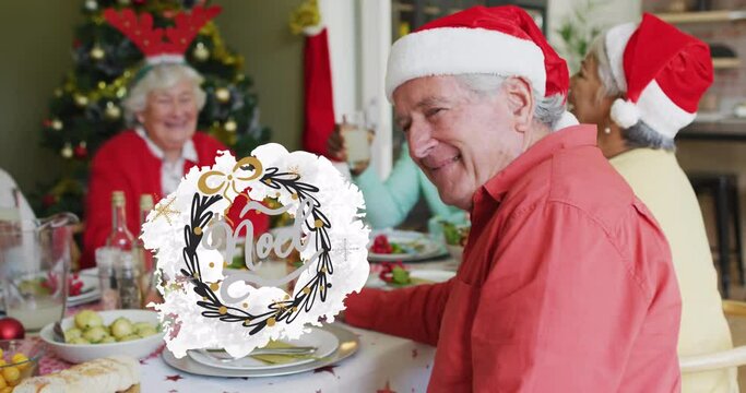 Animation of christmas greetings text over smiling senior caucasian man at christmas meal table