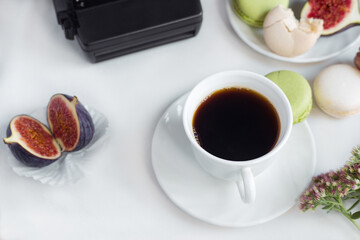 aesthetic film camera flatlay, cups of coffee, figs and macarons on a white background, top view
