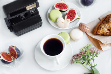 aesthetic film camera flatlay, cups of coffee, figs and macarons on a white background, top view