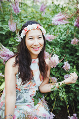 Happy mixed-race Japanese woman with flower hair band in garden