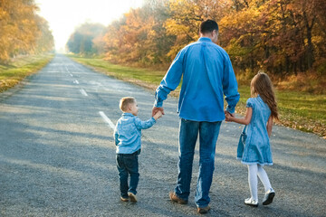 A Happy parent with child are walking along the road in the park on nature travel