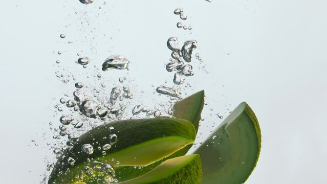 Closeup avocado slices water floating in super slow motion. Organic nutrition.