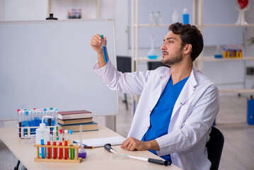 Young male chemist working at the lab