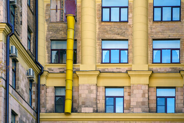 Yellow plastic composite pipe for dumping construction debris on the window of the building