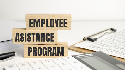 EAP Employee Assistance Program on wooden block and office desk