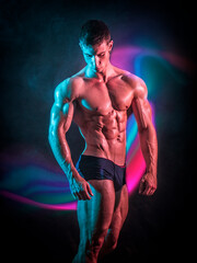 Shirtless muscular young male bodybuilder wearing briefs