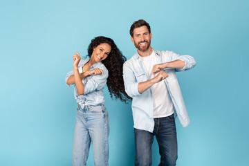 Happy millennial caucasian male with beard and arab female in casual dance, have fun together