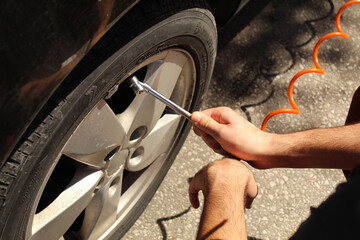 A man hand adjusting the air pressure on a car tire