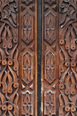 Texture in relief in a Parisian wooden door. The wood is damaged by time and use. The elements of the texture are rounded