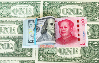 Folded american dollars banknotes wrapped by rubber band and chinese banknote