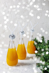 Orange drink decorated with white rabbit on light background for children party.