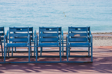 Fototapeta na wymiar Famous blue chairs on the Promenade des Anglais in Nice