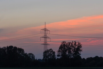 Power pole with power lines in the evening at sunset on the fields near Mering at Mandicho Lake