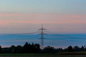 Power pole with power lines in the evening at sunset on the fields near Mering at Mandicho Lake