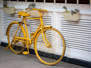 Fototapeta na wymiar Yellow bicycle resting on white wall