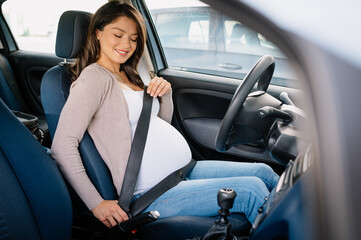 Pregnant woman in a car wearing a seat belt.