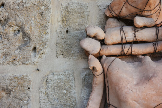 Abstract man sculpture made of stones, boards and wires uprighted in front of a wall. The person who made the work is anonymous, it was left on the street. Izmir, Turkey 09.28.2018