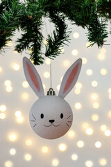 Handmade christmas ball with ears in form of bunny hanging on the christmas tree.