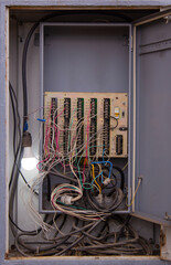 Photo of an electrical panel with wires and switches. Dashboard for controlling electrical equipment. The inside of the wire box. The concept of electricity and power industry in the city. 220 volt