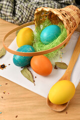 easter eggs in a nest of grass in a basket, wooden background, holiday still life and decorations