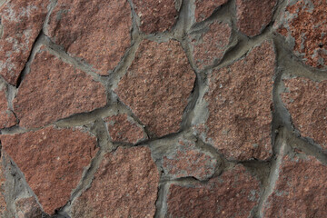 Photo of a stone background. Surface with cracked tile texture. The wall is lined with natural stone. Desktop wallpaper. Place for text. Construction site and outdoor material store concept.