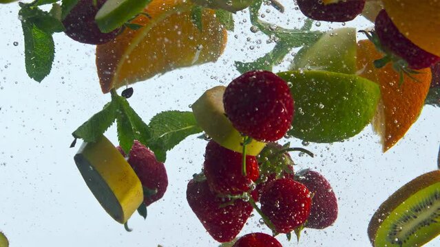 Floating fresh fruits underwater in super slow motion close up. Healthy food.